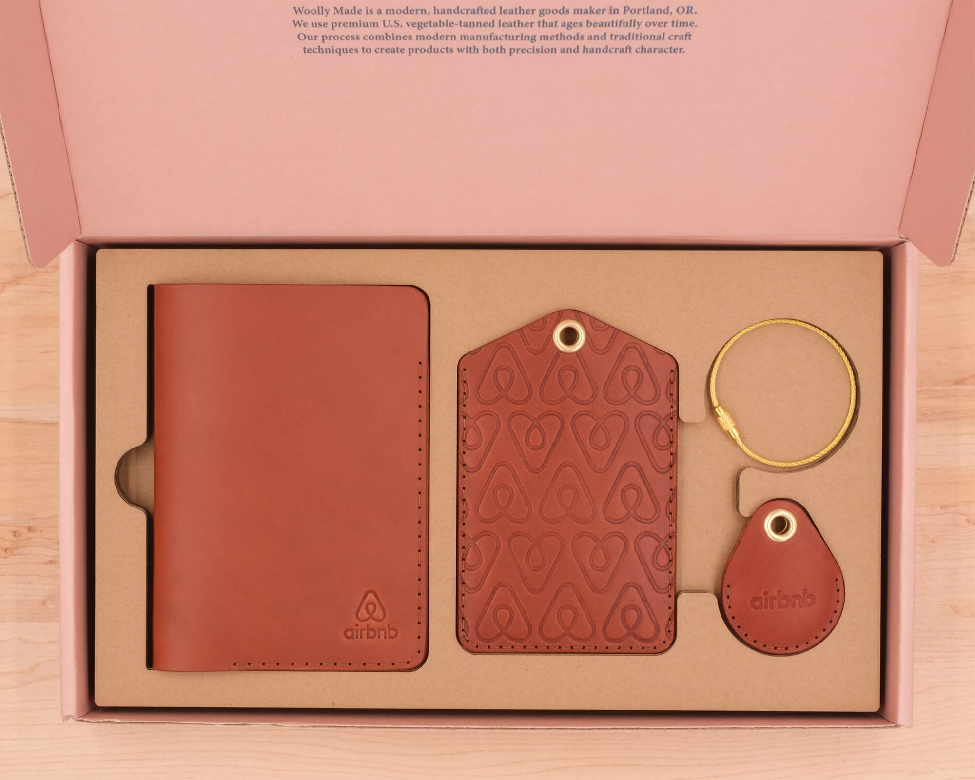 Airbnb branded brown leather Passport Cover, Executive Luggage Tag, AirTag Case, and brass hardware in custom box.