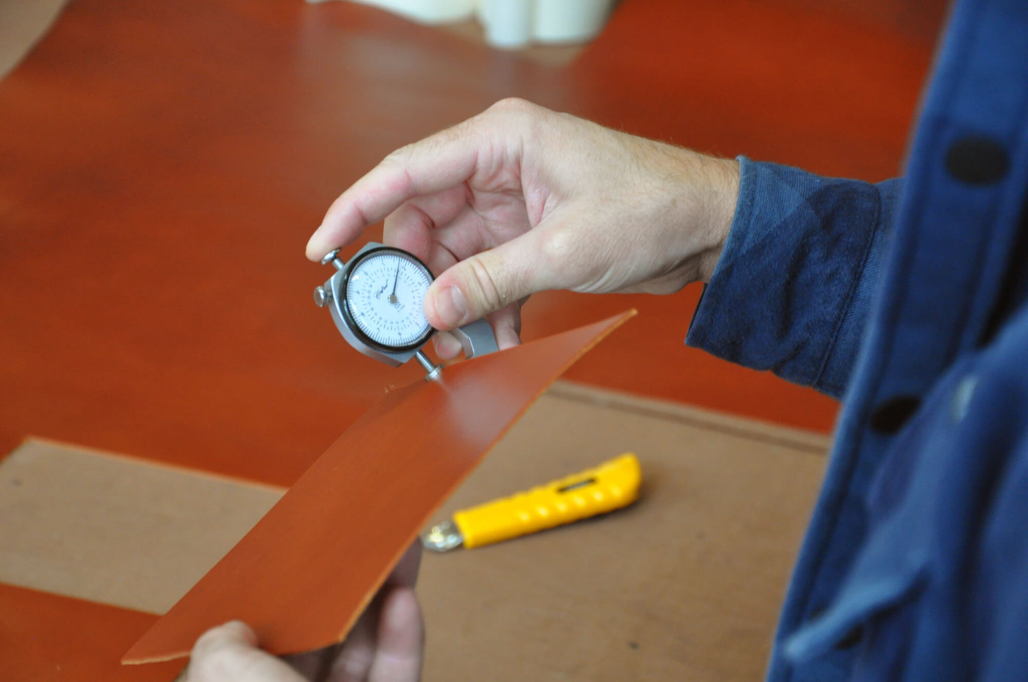Hand holding device to measure leather thickness.