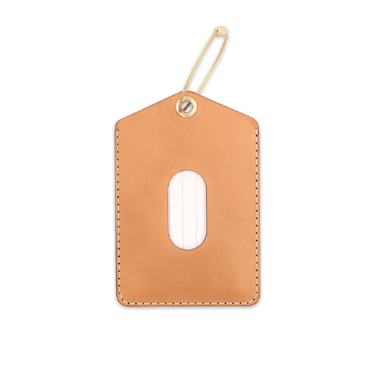 Tan leather rectangular luggage tag with stitching, info card window, and brass hardware.