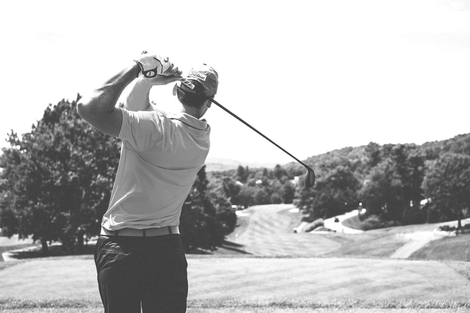 Black and white photo of a person golfing.