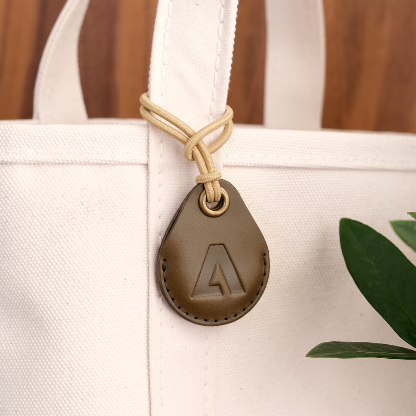 AirTag Case in olive leather and elastic cord.