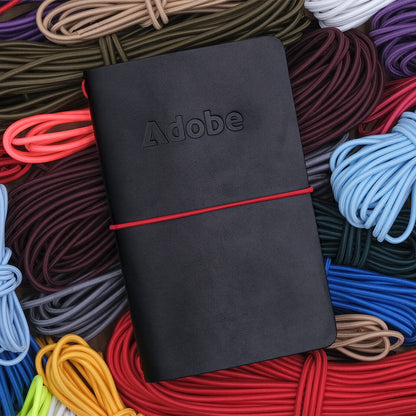 Pocket Journal in black leather, and red elastic cord.