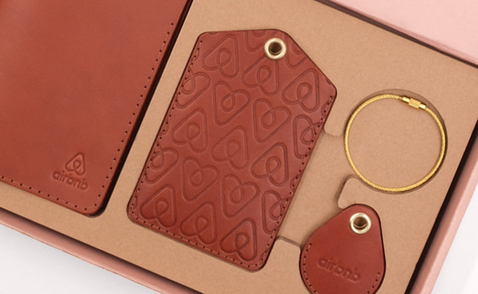 Airbnb branded Passport Cover, Executive Luggage Tag, and AirTag Case in brown leather.