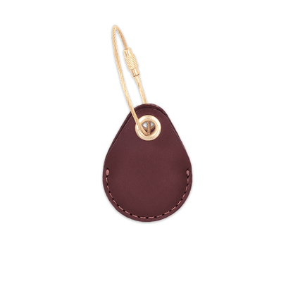 Burgundy leather AirTag holder with brass luggage loop