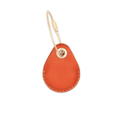 Orange leather AirTag holder with brass luggage loop