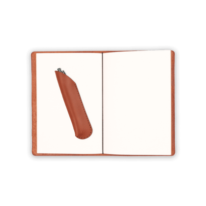 Brown glazed leather journal cover open view with blank notebook, pen in brown leather pen sheath, and elastic strap.