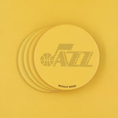 Yellow leather round coasters spread out with Utah Jazz and Woolly Made logos