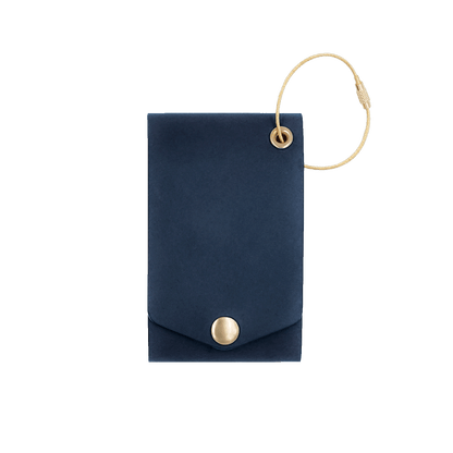 Navy leather luggage tag with fold closure and brass hardware.