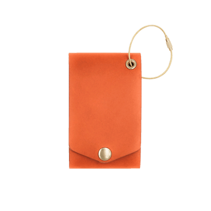 Orange leather luggage tag with fold closure and brass hardware.