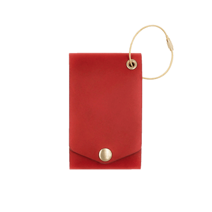 Red leather luggage tag with fold closure and brass hardware.