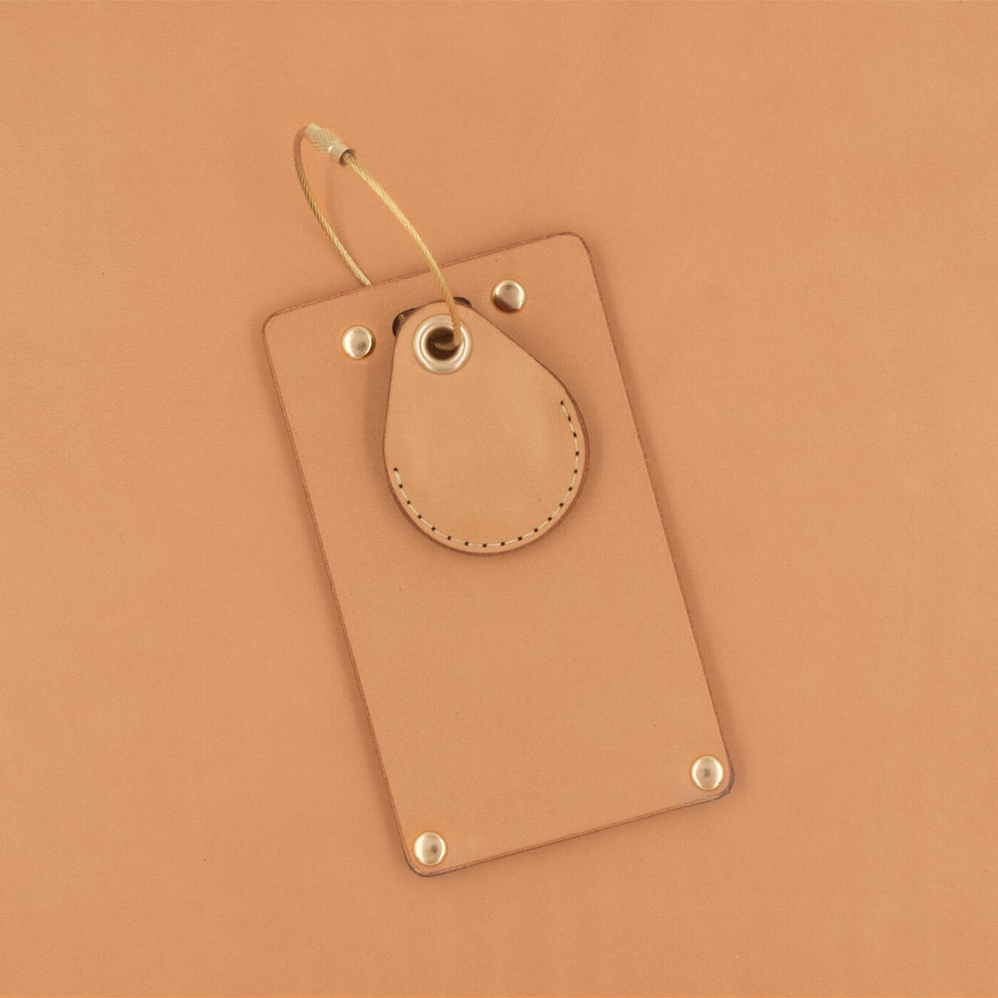 Tan leather rectangular luggage tag front view with brass hardware and tan leather AirTag Case.
