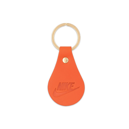 Orange leather teardrop-shaped keychain with brass hardware.