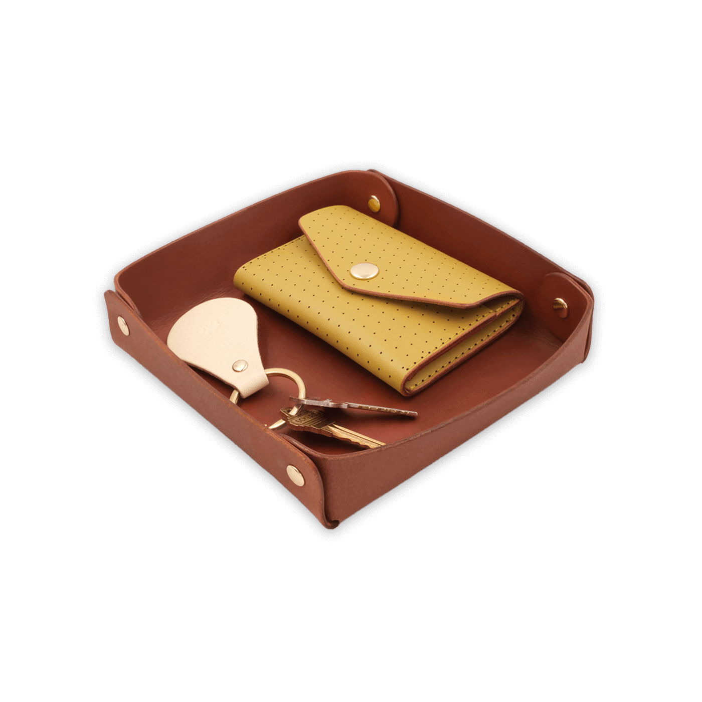 Brown leather valet tray 3/4 angle view with brass hardware, yellow leather Snap Wallet, and tusk leather Tab Keychain with keys.