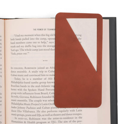 Brown leather rectangular bookmark with diagonal paper slit used on book pages for reference.