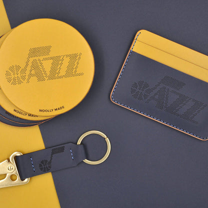 Navy and yellow leather half wallet, round leather coasters, and Clip Keychain with Utah Jazz logo.