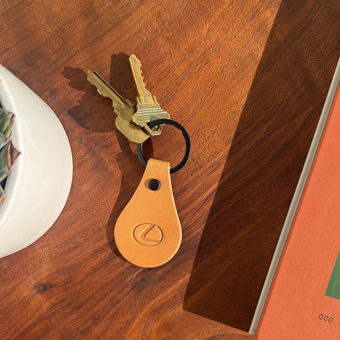 Tan leather Lexus tab keychain, high-quality branded accessory for promotional use.