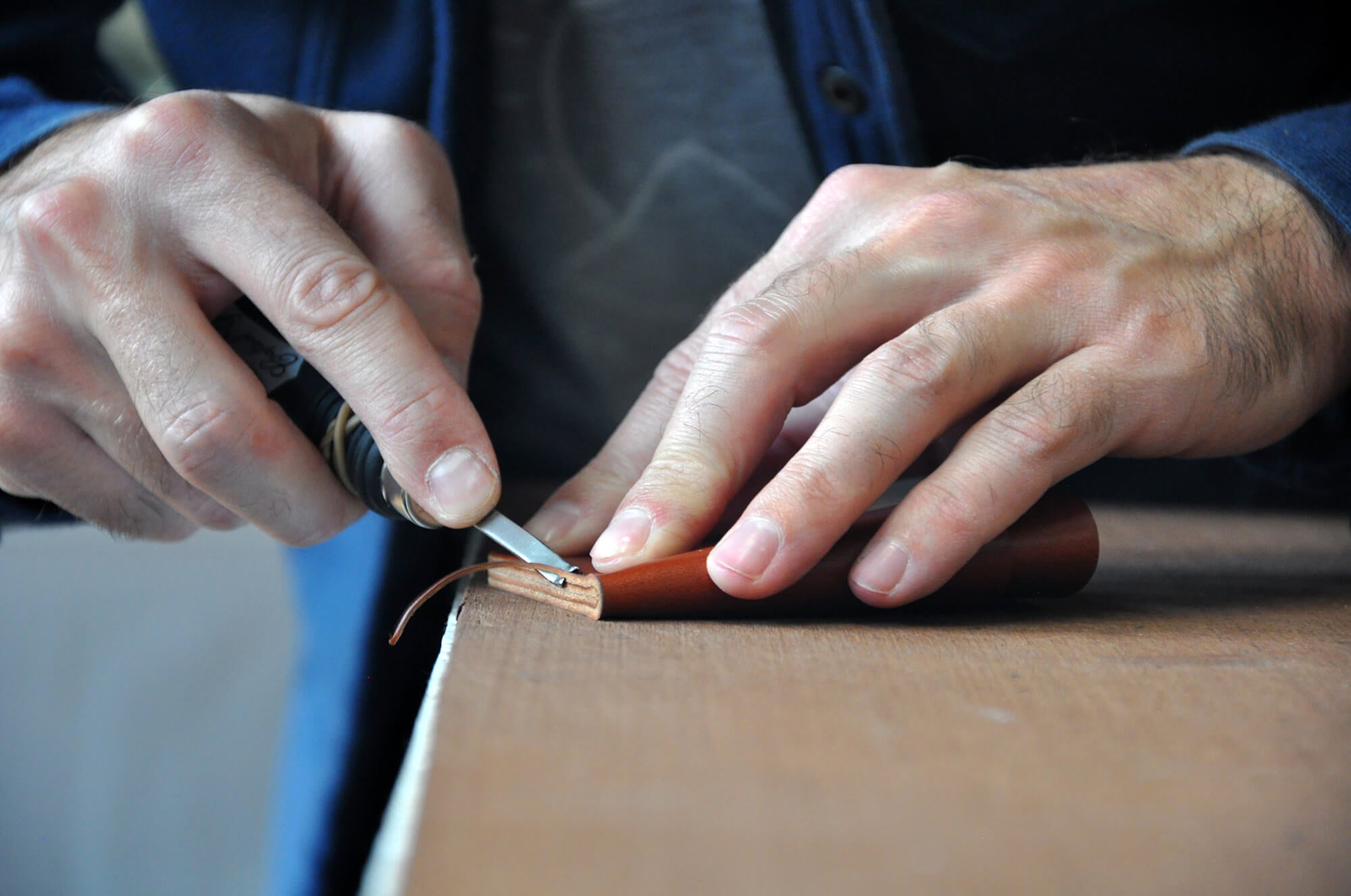 Hands trimming the edges of a Half Wallet.